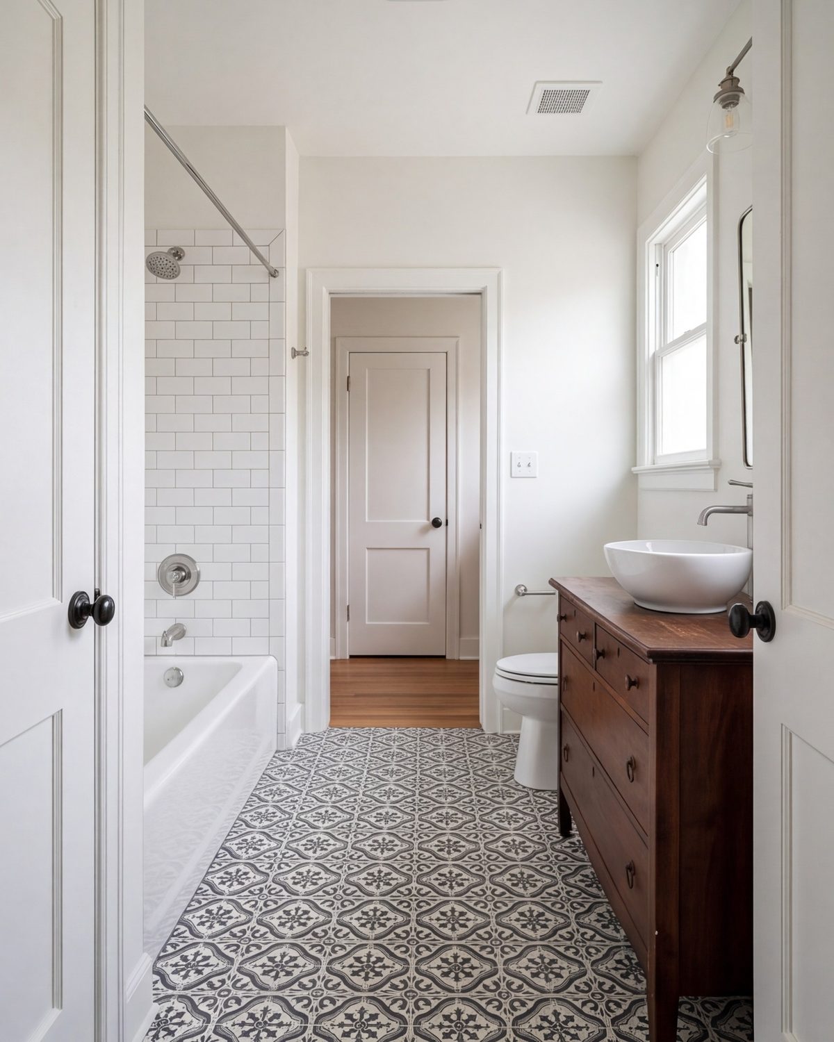 Small hall bathroom with black-and-white tile floor, tub-shower and furniture-style vanity